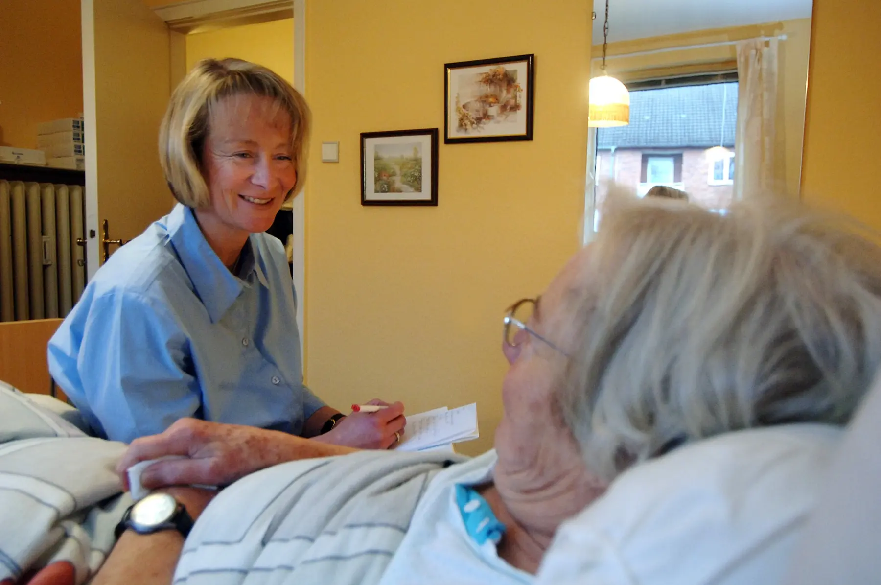Mitarbeiterin von Statz und Maneck im Gespräch mit einer Patientin zu Hause